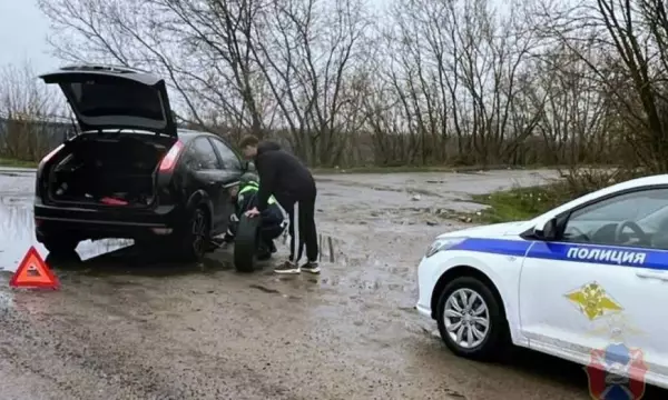 Воронежские полицейские помогли водителю, который под ливнем пытался поменять колесо